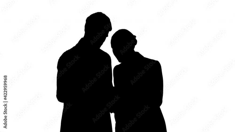 Silhouette Beautiful young business woman and handsome businessman in formal suits are using a digital tablet. Silhouette Beautiful young business woman and handsome businessman in formal suits are using a digital tablet.