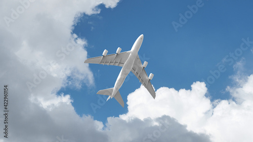 Passenger commercial airplane flying above head as shot from the ground in deep blue cloudy sky