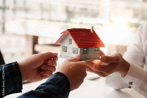 The real estate agent is explaining the house style to the clients who come  to contact to see the house design and the purchase agreement. Stock Photo  | Adobe Stock
