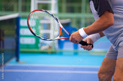 Tennis players playing tennis on a hard court on a bright sunny day