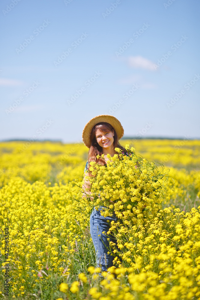 Young, beautiful woman in rapeseed field in the summer. Rural scene with attractive girl in hat enjoying sun in yellow blooming field. Concept of joy, happiness and freedom. Young, beautiful woman in rapeseed field in the summer. Rural scene with attractive girl in hat enjoying sun in yellow blooming field. Concept of joy, happiness and freedom.