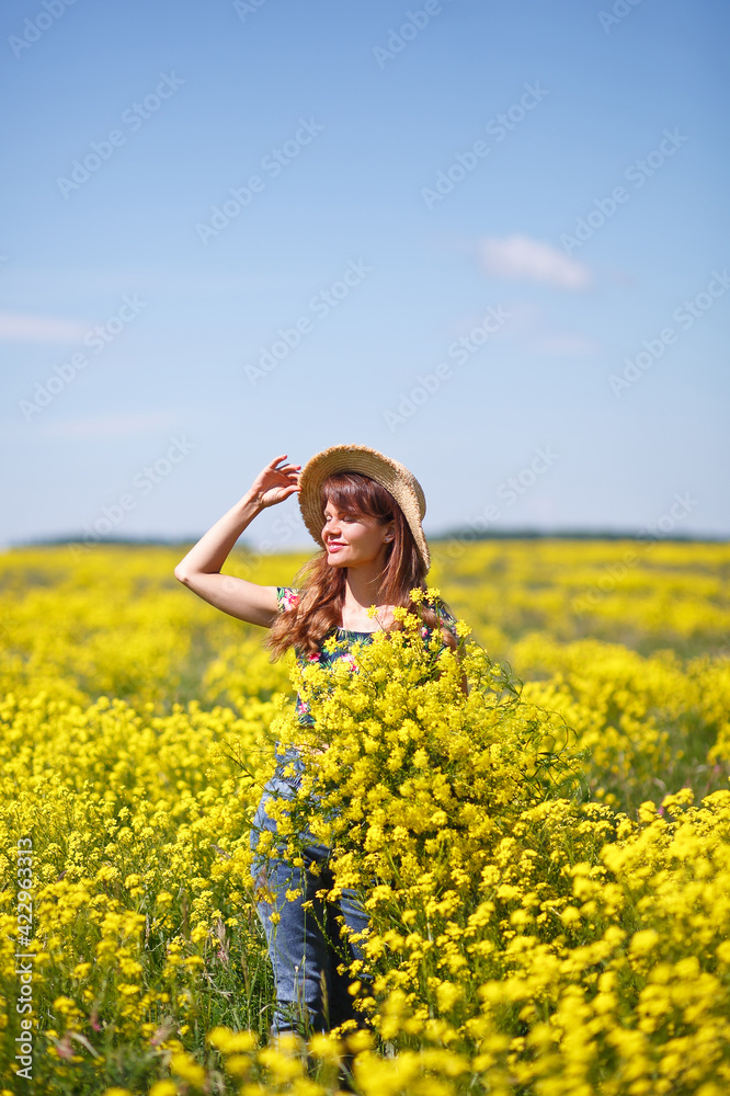 Young, beautiful woman in rapeseed field in the summer. Rural scene with attractive girl in hat enjoying sun in yellow blooming field. Concept of joy, happiness and freedom. Young, beautiful woman in rapeseed field in the summer. Rural scene with attractive girl in hat enjoying sun in yellow blooming field. Concept of joy, happiness and freedom.