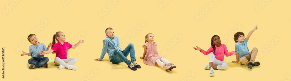 Little and happy kids gesturing isolated on yellow studio background. Human emotions, facial expression concept Little and happy kids gesturing isolated on yellow studio background. Human emotions, facial expression concept