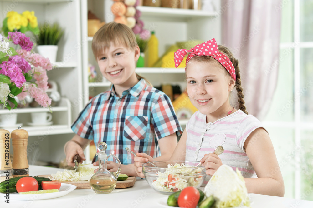 Cute brother and sister cooking together in kitchen Cute brother and sister cooking together in kitchen