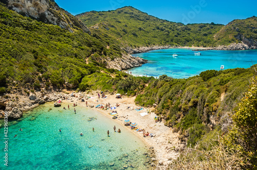 Porto Timoni beach on Corfu island in Greece. Beautiful panoramic view of green mountains, clear sea water, secluded Pirates bay and double stony beach. Famous destination for summer vacation