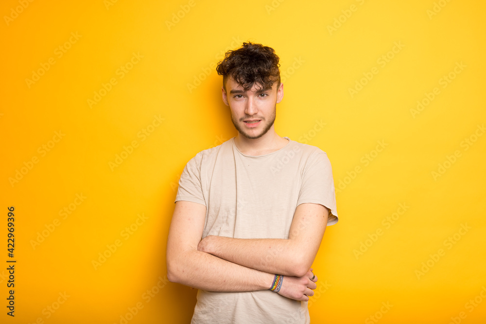 Junger Mann im T-Shirt vor einem gelben Hintergrund Junger Mann im T-Shirt vor einem gelben Hintergrund