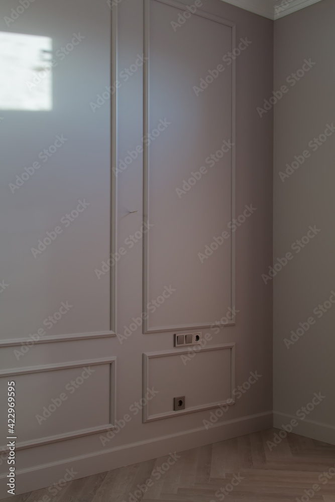 Close up view of modern and bright corner of empty cream room with ray of sunlight on wall and herringbone parquet floor Close up view of modern and bright corner of empty cream room with ray of sunlight on wall and herringbone parquet floor