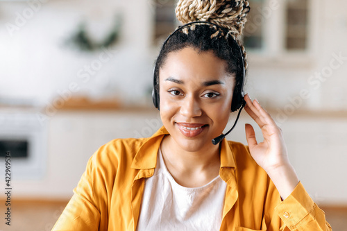 Photography Close-up of African American an attractive confident young woman in headset, sit