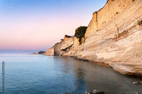 Logas sunset beach with sheer white cliffs in Peroulades village on Corfu Island in Greece. Loggas is famous for scenic viewpoint with sunset sea view from high rocky limestone cliff photo