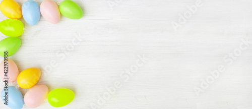 Pastel-colored easter eggs on white wooden board, header, headline, banner, panorama