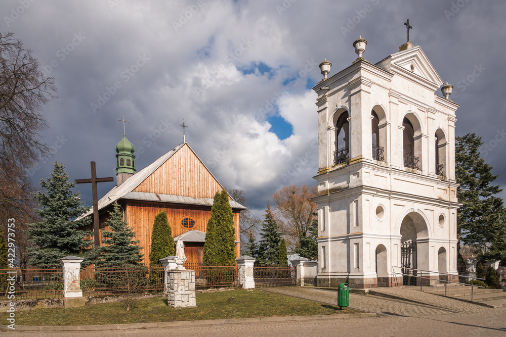 Wooden church and historic brick belfry in Warszawice, Masovia, Poland