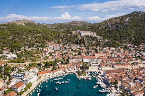Stunning aerial view of the famous Hvar island and old town with its yachts harbor and the Spannish fortress in Croatia on a sunny summer day