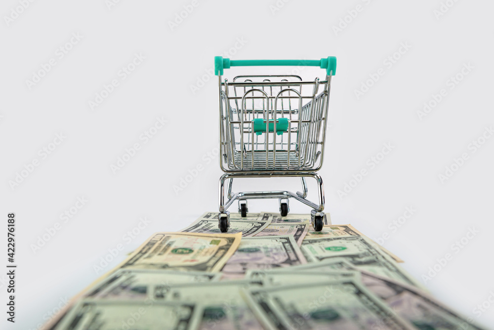 shopping cart on US dollars banknotes road isolated on white background, selective focus
