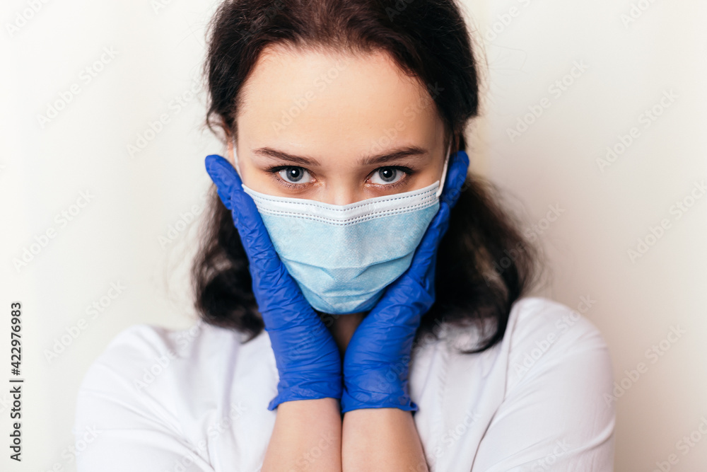 Nurse shy young medic puts on rubber disinfected gloves. Female doctor dressed in medical gown and surgical face blue mask. Image with copy space. Pandemic virus coronavirus concept
Nurse shy young medic puts on rubber disinfected gloves. Female doctor dressed in medical gown and surgical face blue mask. Image with copy space. Pandemic virus coronavirus concept
