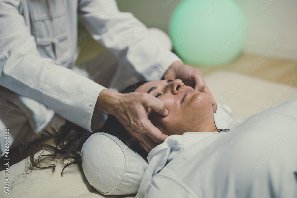 Therapist man doing a Shiatsu massage to a woman. Holistic therapy, treatment with manipulation by thumb, fingers and palms. Wellness, health, relax, well-being and alternative medicine concept. Therapist man doing a Shiatsu massage to a woman. Holistic therapy, treatment with manipulation by thumb, fingers and palms. Wellness, health, relax, well-being and alternative medicine concept.