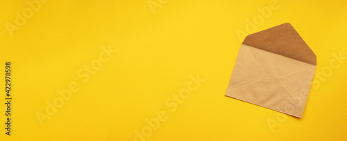 Brown envelope template mock up on a yellow background. Flat lay, top view.