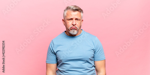 old senior man feeling sad and whiney with an unhappy look, crying with a negative and frustrated attitude