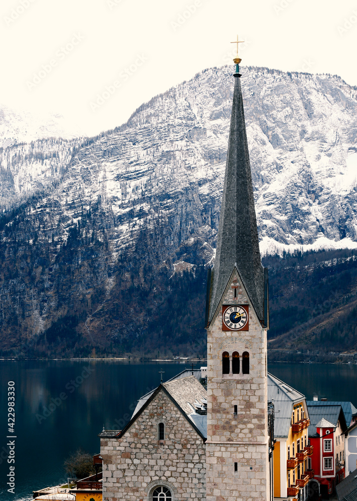 View of Hallstatt famous church with lake and Alps behind, Austria