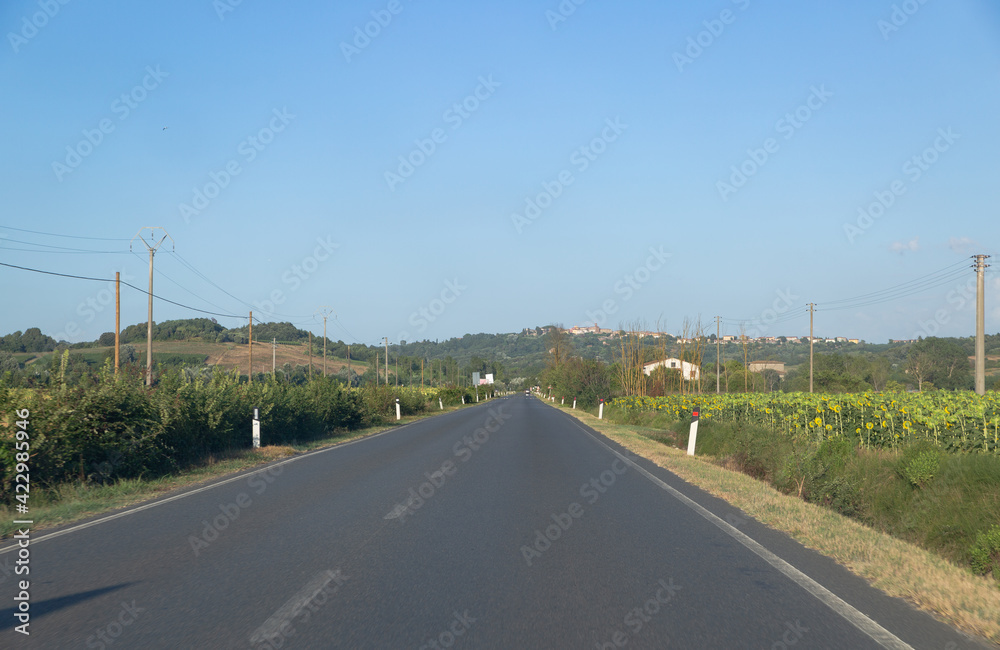 Empty road and green hill in Tuscany, Italy