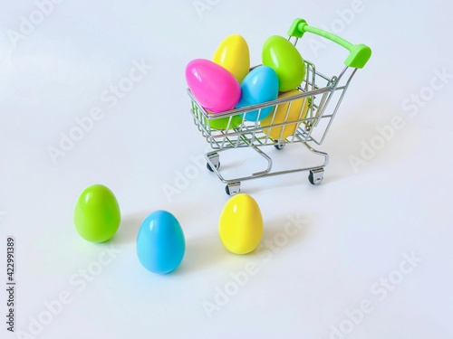 Easter.  Multicolored bright colorful Easter eggs in a supermarket trolley.  Isolated over white background.  Easter holiday concept.