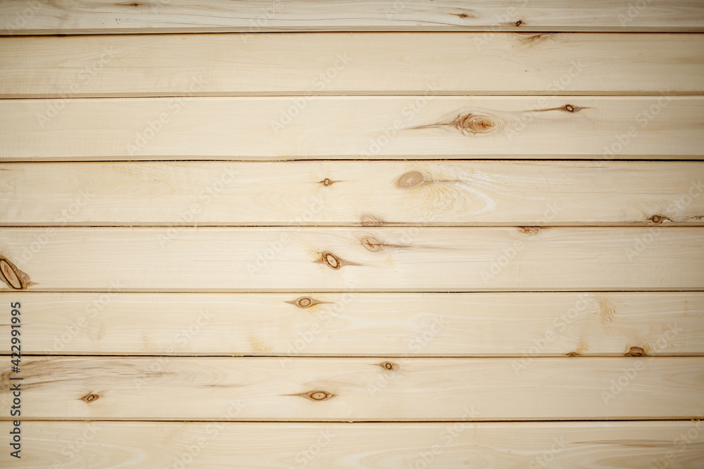 Fototapeta premium The background is a wall made of wooden beams.Texture for your design. Wooden beam and board. Background for still life. Beautiful wood texture. 
