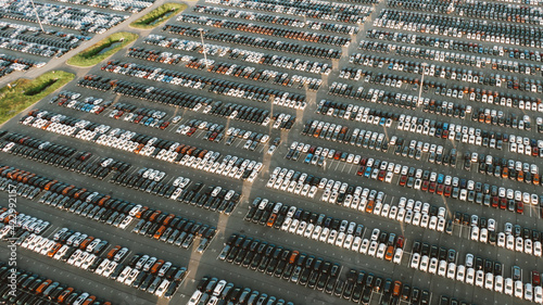 Huge parking with new cars in the territory of an automobile factory  aerial view. Overproduction of goods  economic crisis  no buyers.