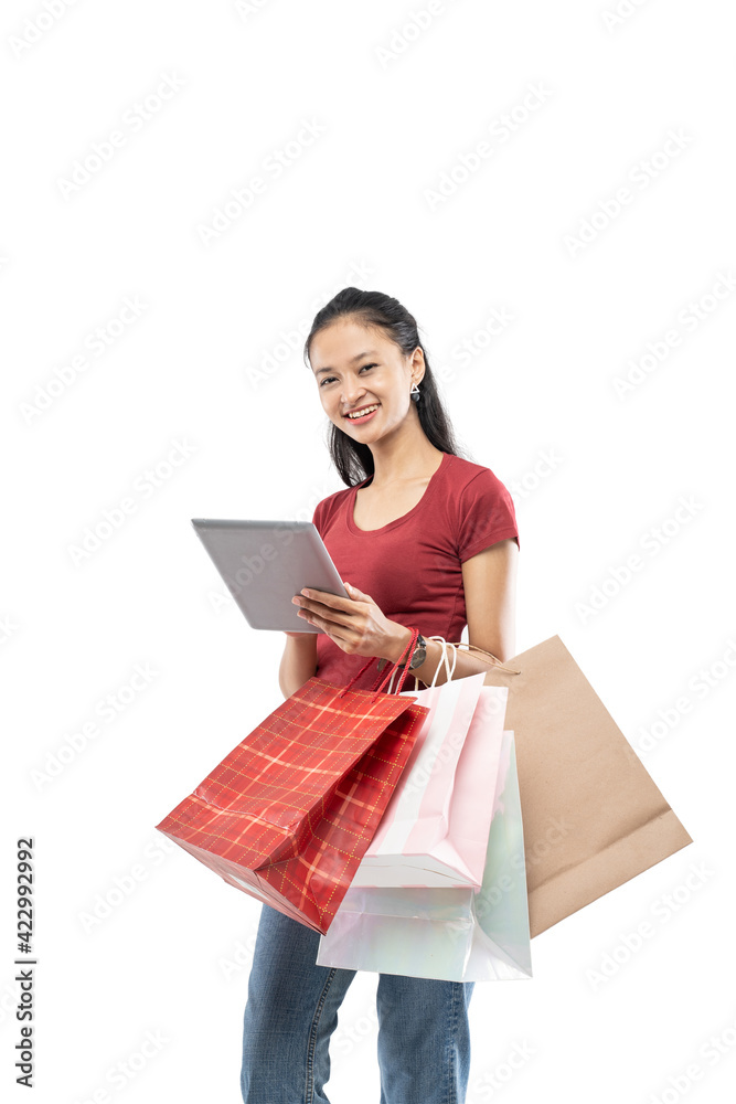 Beautiful woman holding a shopping bag and tablet with smile expression on white background Beautiful woman holding a shopping bag and tablet with smile expression on white background