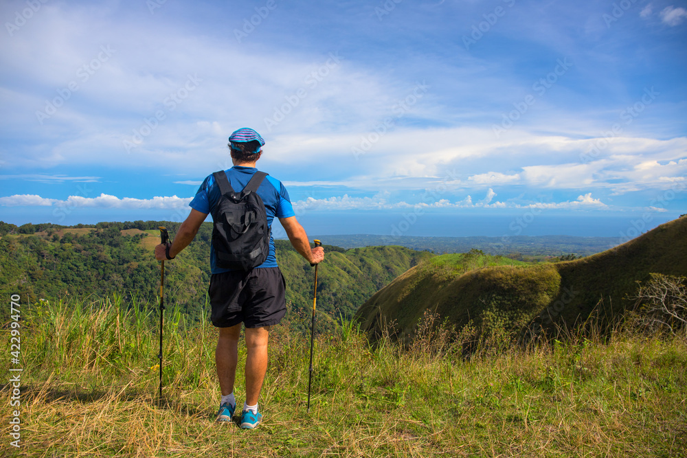 Trekker with backpack on the top of hill on natural mountain landscape. Tourist travels through the mountains. Photos of holidays in beautiful places. Tracker conquers mountain peaks. Outdoor activity Trekker with backpack on the top of hill on natural mountain landscape. Tourist travels through the mountains. Photos of holidays in beautiful places. Tracker conquers mountain peaks. Outdoor activity