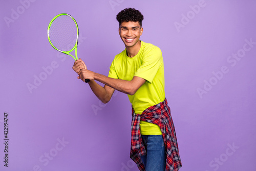 Photo of young black sportsman happy positive smile hold tennis racket play badminton isolated over purple color background © deagreez