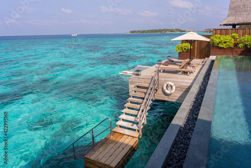 Luxurious exterior of a very expensive rich water villa in the Maldives, decorated with natural wood. photo