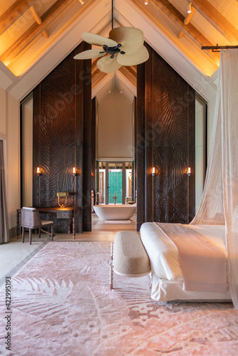 Luxurious interior of a very expensive rich water villa in the Maldives, decorated with natural wood. photo