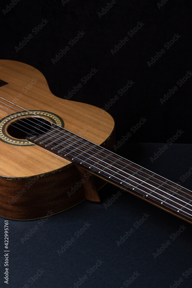 Obraz premium Guitar on a black background. Acoustic guitar on a dark background. Classical spanish guitar