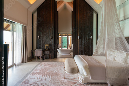 Luxurious interior of a very expensive rich water villa in the Maldives, decorated with natural wood. photo
