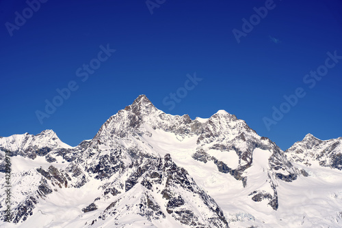 Snow capped mountains, snowfields and glaciers at Zermatt, Switzerland, seen from Gornergrat railway station. Photo taken March 23rd, 2021.