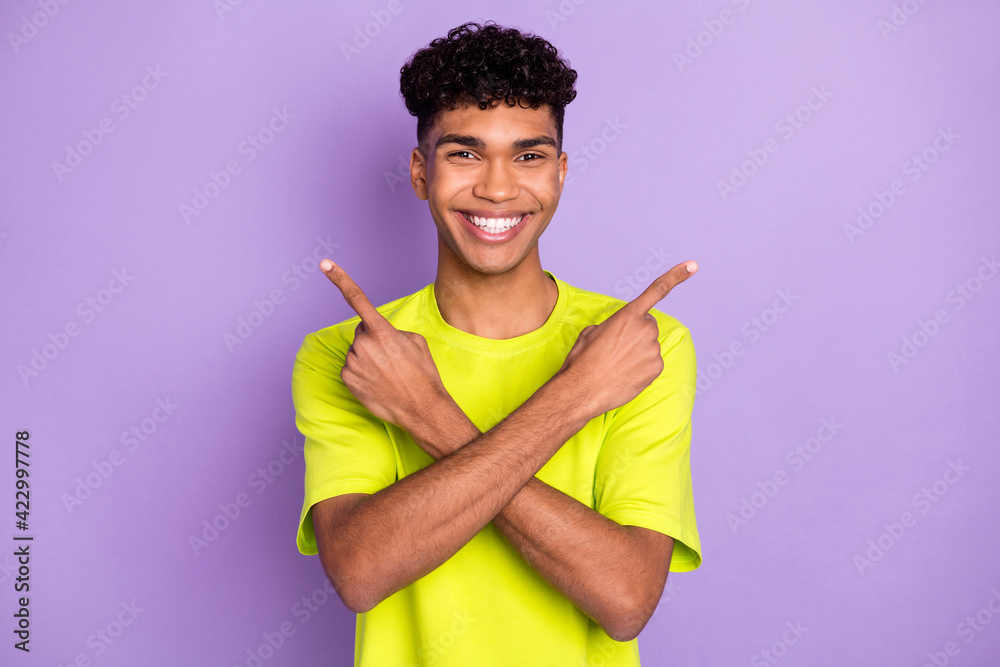 Photo of young afro man happy smile crossed hands indicate fingers empty space ad promo choice isolated over purple color background Photo of young afro man happy smile crossed hands indicate fingers empty space ad promo choice isolated over purple color background
