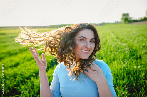 Fotografía Curly brunette enjoys sunshine in summer day
