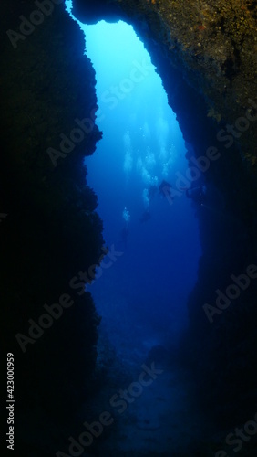 cave diving underwater scuba divers exploring caves and having fun ocean scenery sun beams and rays background
