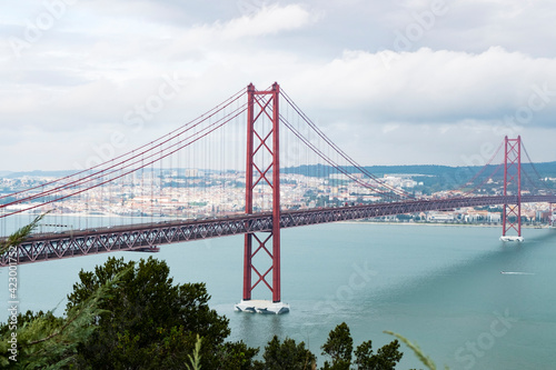 Modern bridge On April 25 in Lisbon, the capital of Portugal, in cloudy cloudy weather, cars drive on the gigantic bridge across the strait. © wifesun