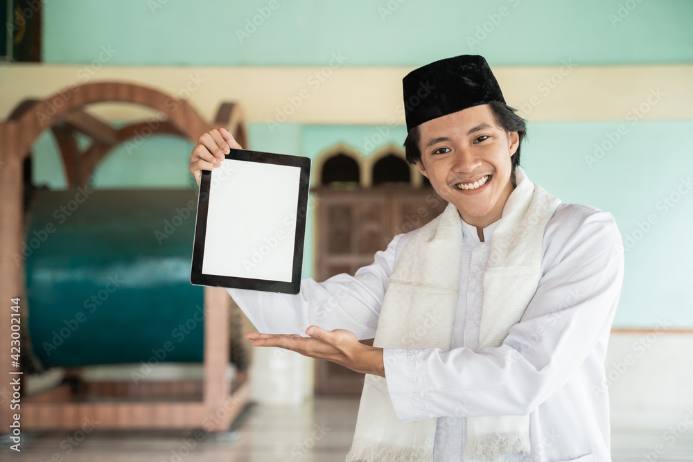 asian man muslim smiling holding and showing blank tablet in mosque asian man muslim smiling holding and showing blank tablet in mosque