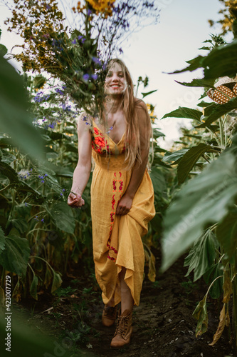 Summer outfit, Summer fashion, natural beauty. Outdoor candid portrait Young blonde woman n ristic yellow dress and straw hat on green field nature background photo