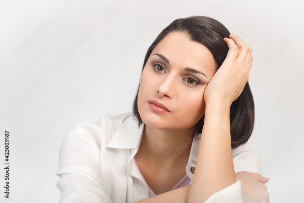 High-key studio portrait of a young sadness woman in light clothes looking into the distance High-key studio portrait of a young sadness woman in light clothes looking into the distance
