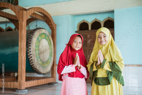 Kids girl asian Muslim pose welcome gesture hand in mosques photo