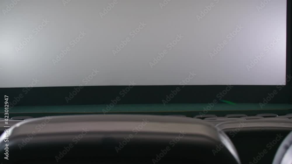 Interior cinema hall with white screen and black chairs. Interior cinema hall with white screen and black chairs.