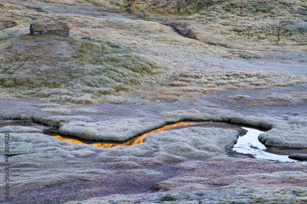 Frosted high mountain landscape with stone house and a stream Frosted high mountain landscape with stone house and a stream