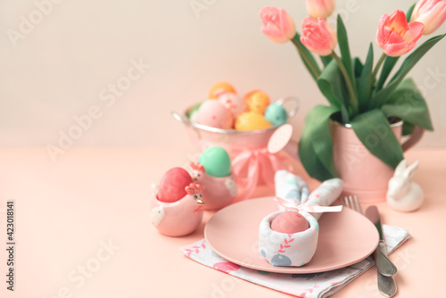 Festive Easter table setting with napkin Easter Bunny on pink table. Easter celebration concept. Soft focus. Copy space