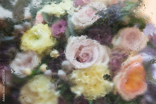 Beautiful bouquet of blurred vintage flowers. Roses, carnationon and leaves on dark background.