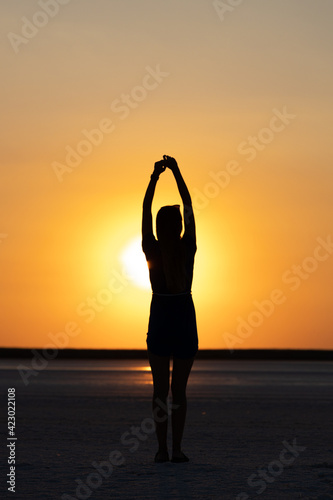 Silhouette of a girl posing at sunset or sunrise. Walking outdoors during warmer times