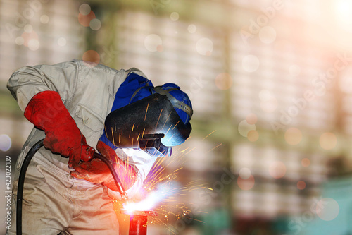Welder uses MIG torch to make sparks during manufacture of metal equipment.