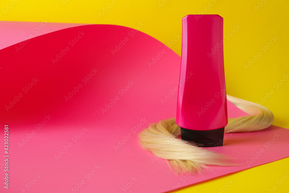 Bottle of hair shampoo and strand on color background Bottle of hair shampoo and strand on color background