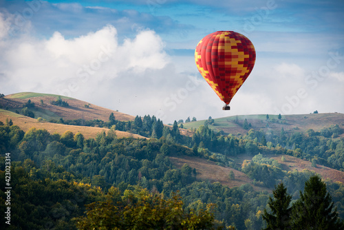 Hot air balloon flying over mountains © Antonio